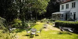 De tuin met gezellige zitplaatsen van hotel au nom de dieu in lanklaar